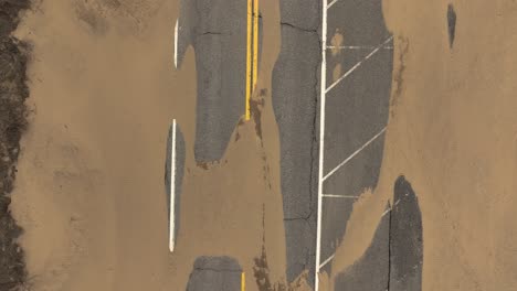 direct aerial over sand strewn road