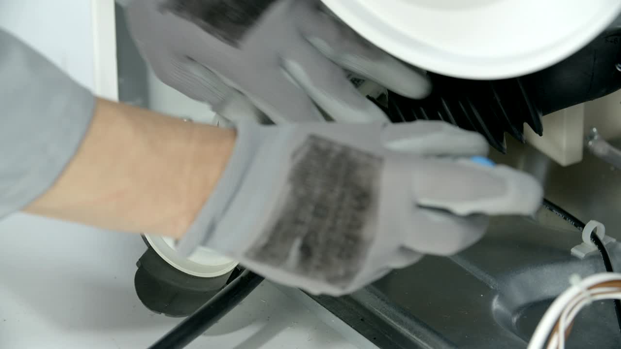 수리 직원이 배수 프에서 배수 호스를 당기고 있습니다.