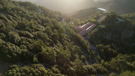 An-aerial-view-of-the-historic-Kykkos-Monastery-nestled-in-the-serene-mountains-of-Cyprus,-illuminated-by-the-soft-morning-light