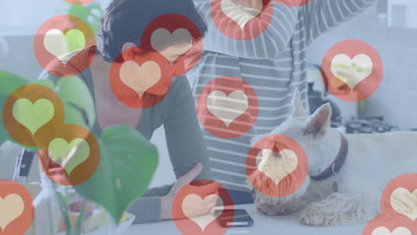 animación de emojis de corazón sobre una feliz pareja de mujeres caucásicas enamoradas de un perro.