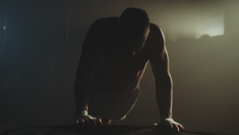 man performing push-ups on a tire in a gym