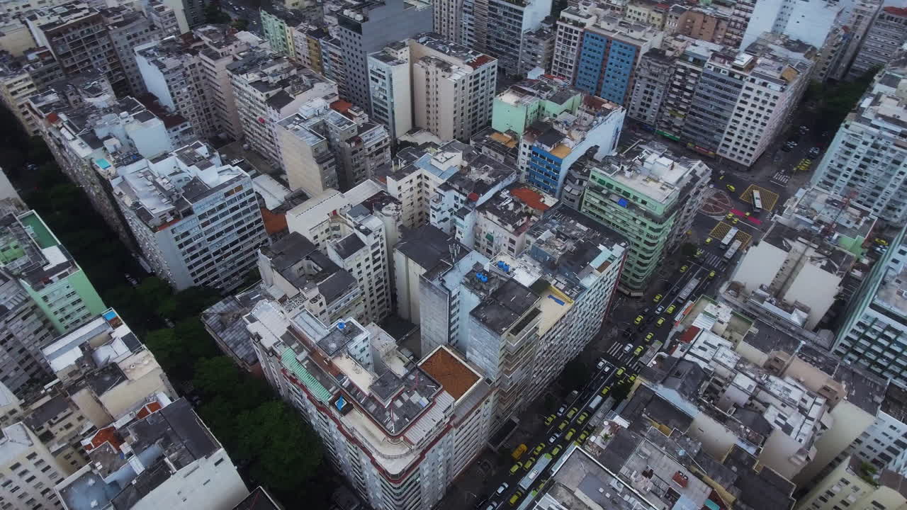 Vista aérea orbitando sobre edifícios densos e o tráfego de rua no Rio