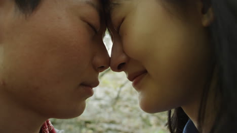 loving asian lesbian couple touching foreheads