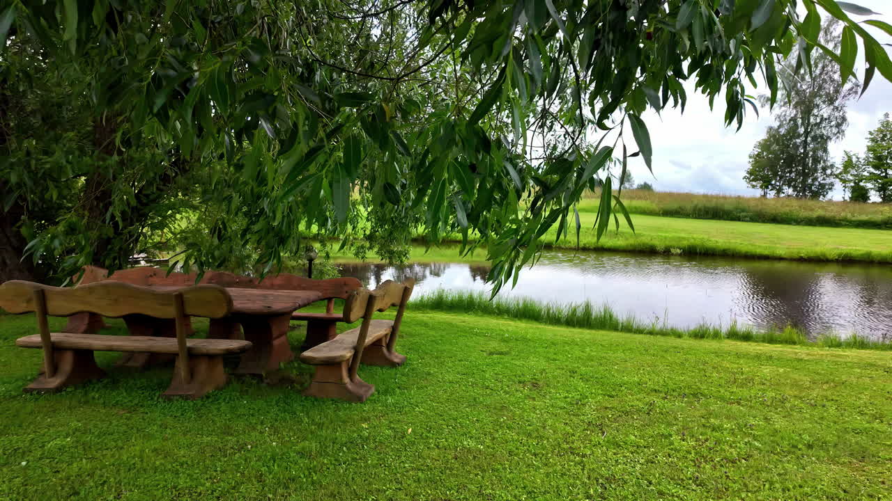 조용한 연못 의 나무 에 있는 나무 피크닉 테이블과 함께 조용한 야외 장면