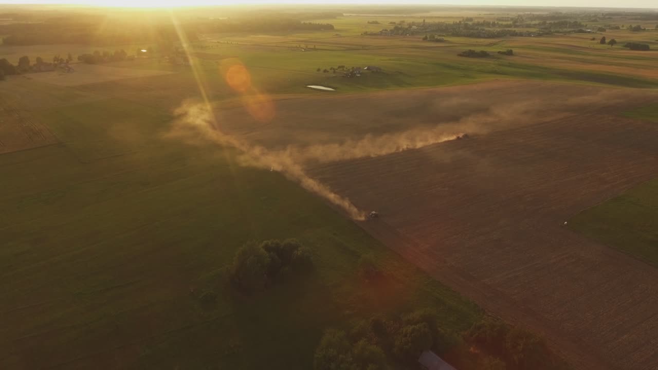 Heavy Agricultural Machinery In Agricultural Fields On A Sunny Summer Evening. Aerial Dolly-Out Shot