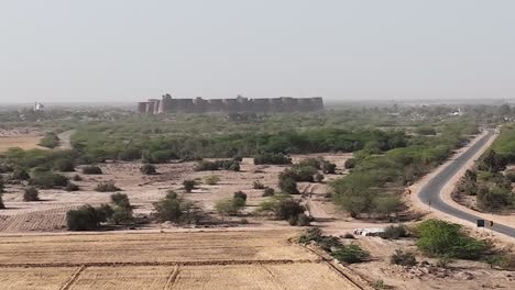 Aerial-View-Of-Derawar-Fort-In-the-Distance-Located-In-Ahmadpur-East-Tehsil,-Punjab,-Pakistan