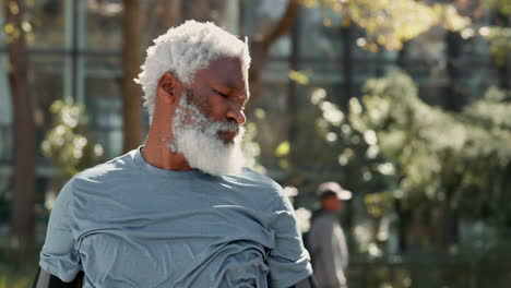older man with a white beard holding his shoulder in pain