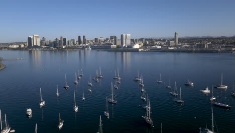 aerial view of sailboats in a bay with a city skyline