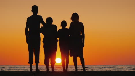 feliz familia multigeneracional disfrutando de la puesta de sol sobre el mar