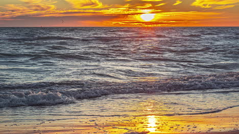 Zeitrafferaufnahme-Eines-Kindes,-Das-Während-Des-Sonnenuntergangs-Am-Strand-Mit-Den-Meereswellen-Spielt