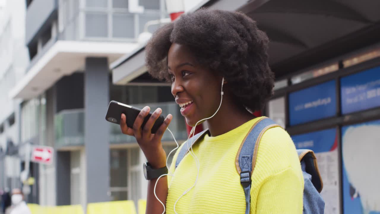 afroamericana usando su teléfono inteligente en la calle