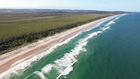 long sandy stretch of seven mile beach with forested coastline in shoalhaven area of new south wales, australia. aerial shot, slow motion