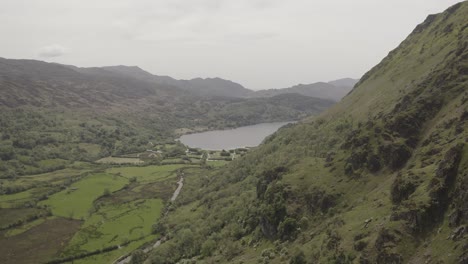 Vuelo-Junto-A-Una-Montaña-Hacia-Un-Lago