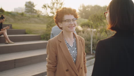 multiethnic businesswomen shaking hands and speaking on street