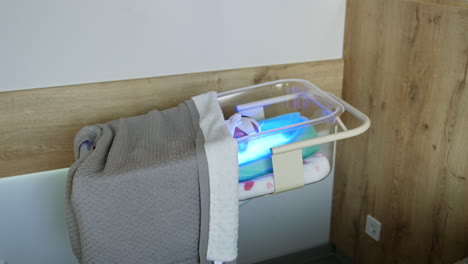 transparent crib with newborn kid covered with blanket. the baby is cured from jaundice in maternity hospital.