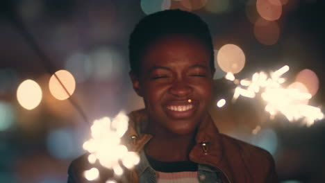 beautiful african american woman holding sparklers dancing on rooftop at night celebrating new years eve enjoying holiday celebration