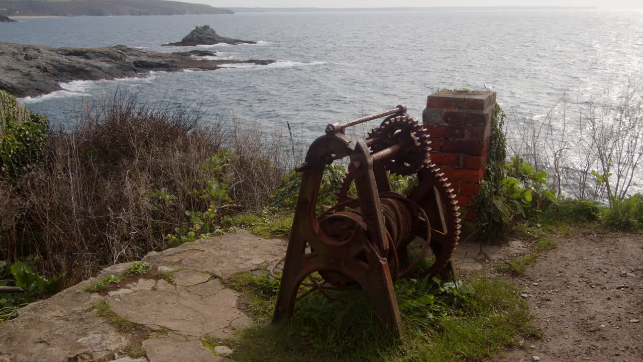 Wide shot of old fisherman's rusting winching equipment with the city in the background, cornwall