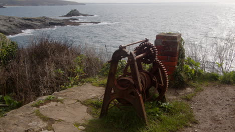 Wide shot of old fisherman&#039;s rusting winching equipment with the city in the background, cornwall