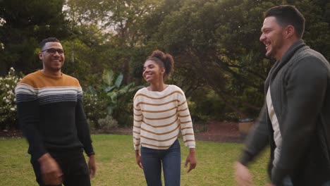 una joven africana sonriente llamando a sus amigas por apilar sus manos y levantarlas en el parque
