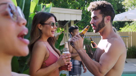 grupo de amigos sonrientes al aire libre bebiendo cerveza y disfrutando de la fiesta de la piscina de verano