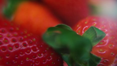 Vídeo-Macro-Detallado-De-Un-Montón-De-Fresas,-Fresa-Roja-Cruda,-Hoja-Verde,-Sobre-Un-Soporte-Giratorio,-Movimiento-Suave,-Cámara-Lenta-120fps