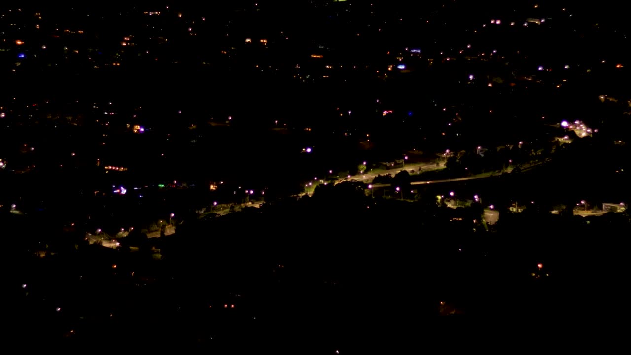 vista nocturna de la carretera del centro de la ciudad iluminada con tráfico distante