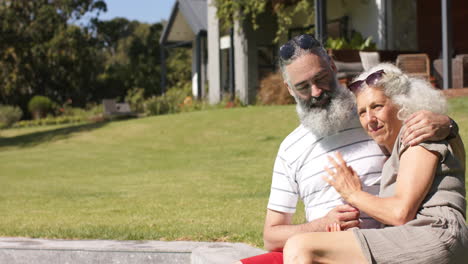 senior couple sitting outdoors on grass, enjoying sunny day together, copy space