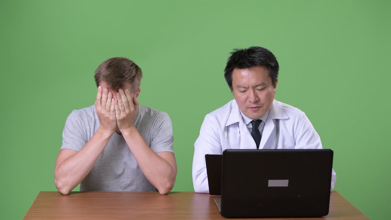 Mature Japanese man doctor and young patient having discussion