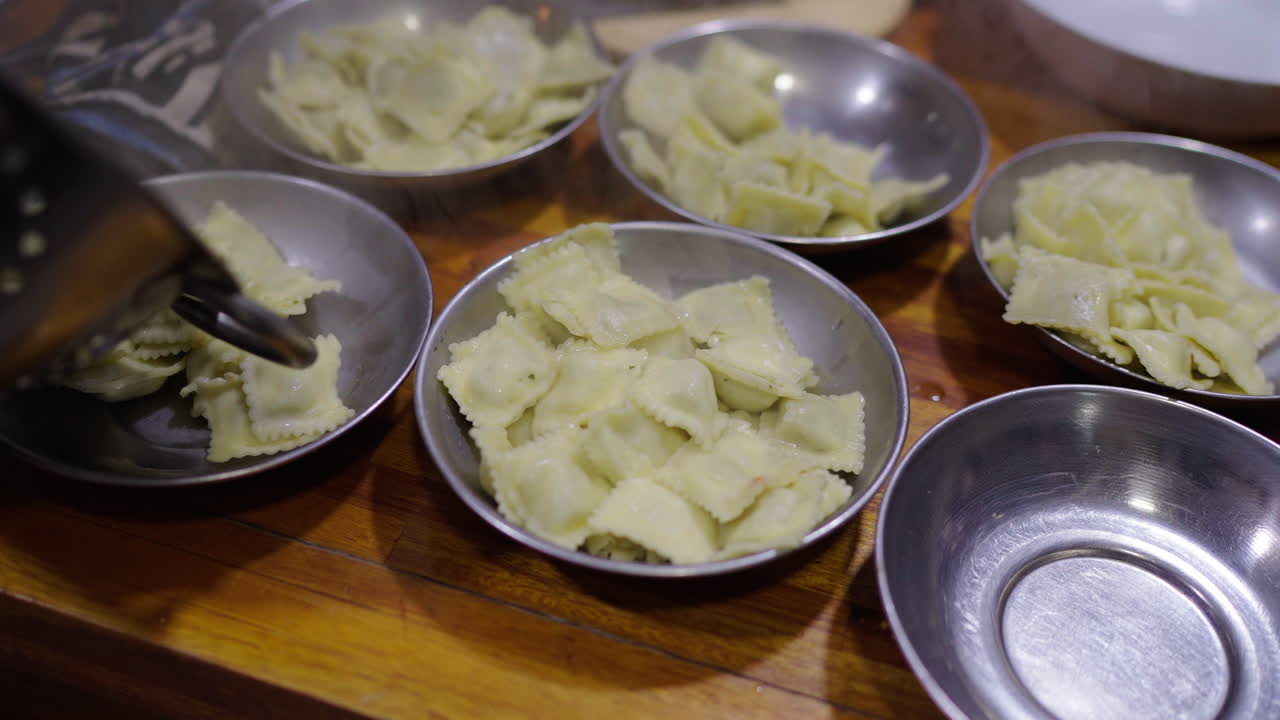 Placing freshly made ravioli onto different plates in a warm, inviting home kitchen