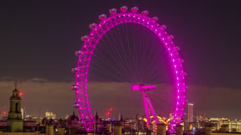 el ojo de londres por la noche, iluminado en rosa