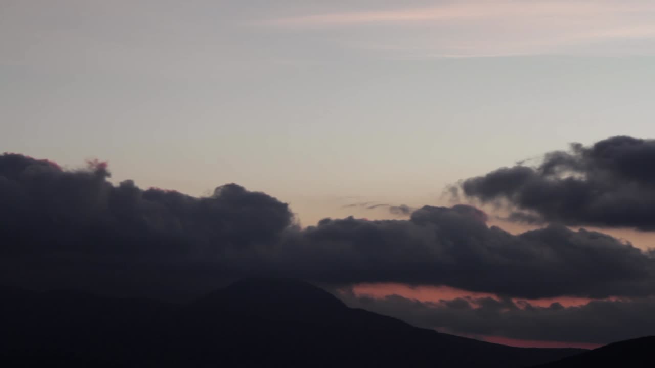 극적인 구름과 함께 산 위에 해가 지는 것