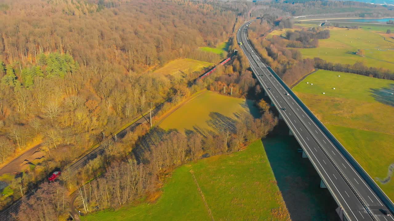 Aerial View of a Highway Bridge and Train Tracks Through a Rural Landscape