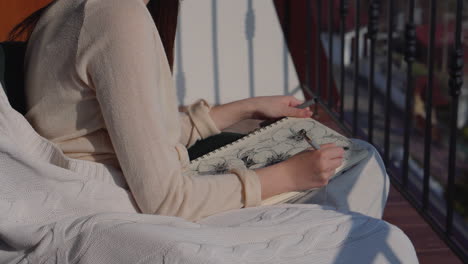 woman drawing flowers on a balcony