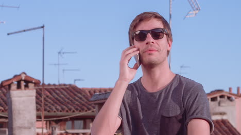 man talking on phone on rooftop