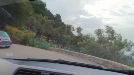 Un-Paseo-En-Sant-Llorenç-Carretera-En-Zigzag-Que-Muestra-La-Vegetación-Tradicional-Del-Pueblo-Mallorquín,-Siguiendo-Un-Coche-Mallorca,-España,-Capturado-Desde-El-Parabrisas-Del-Coche