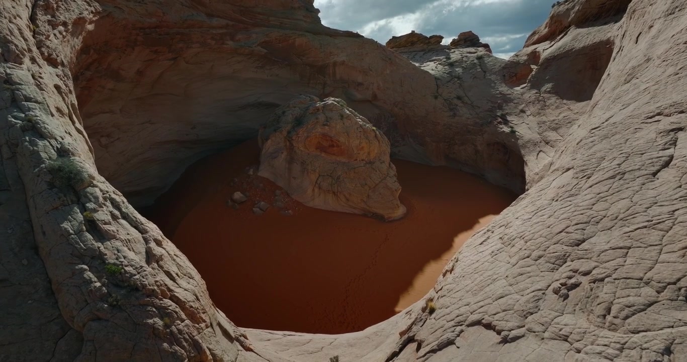 Un bacino liscio di arenaria bianca racchiude sabbia color ruggine sotto un cielo desertico spettacolare, Cosmic Ashtray, Utah