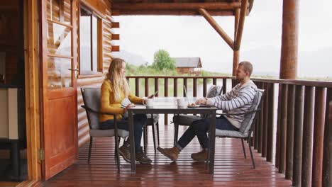 caucasian couple spending time at home together, sitting outside the cabin