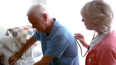 Female-doctor-examining-senior-mans-back-with-a-stethoscope