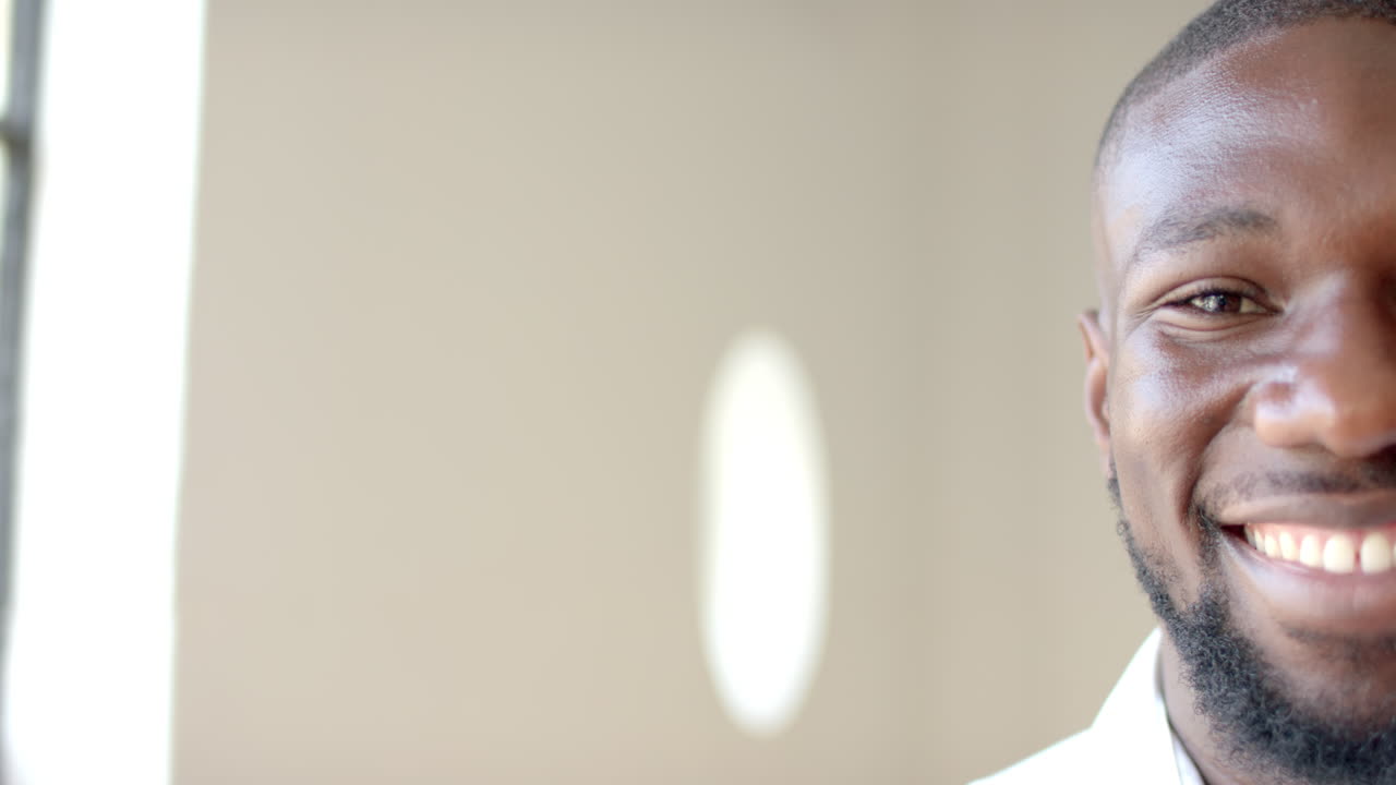 Smiling man in business attire, close-up portrait in office setting, copy space
