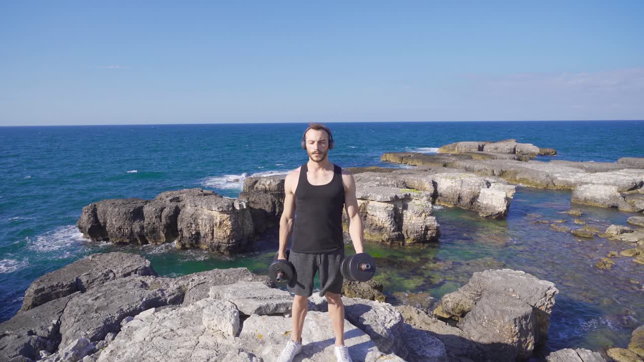 un atleta levantando pesas en la playa.