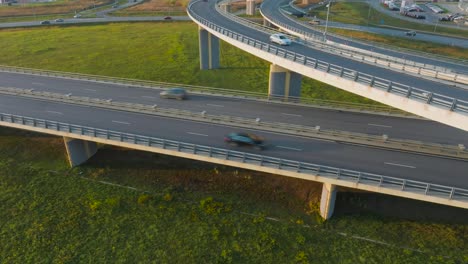 una carretera rural con un puente y pasos elevados por los que circulan coches y camiones