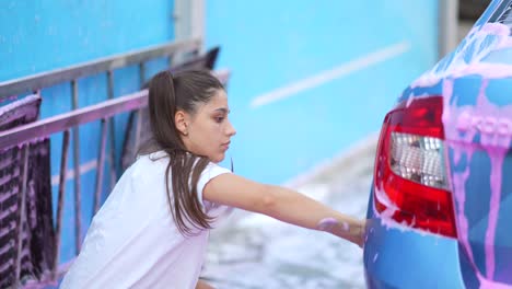 mujer lavando un coche en un lavado de coches