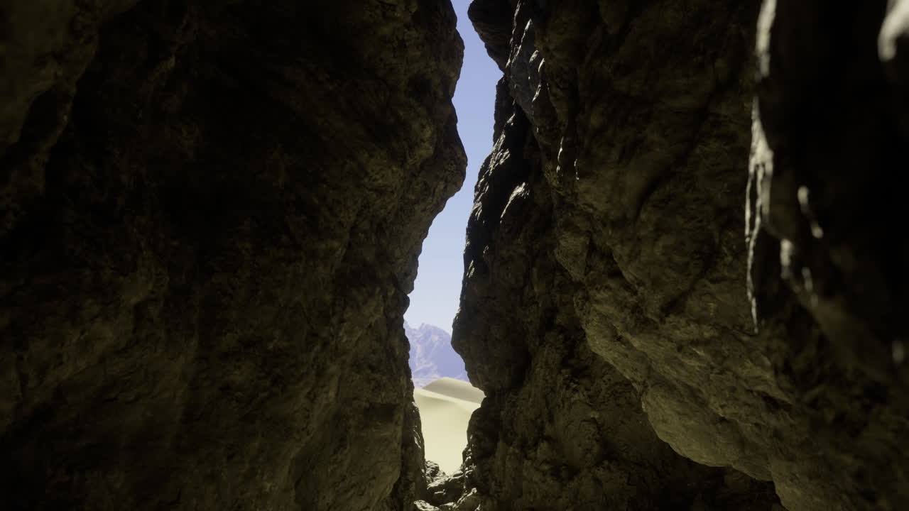 Rocky crevice revealing sunlit landscape at midday in a desert setting