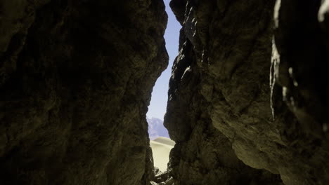 rocky crevice revealing sunlit landscape at midday in a desert setting