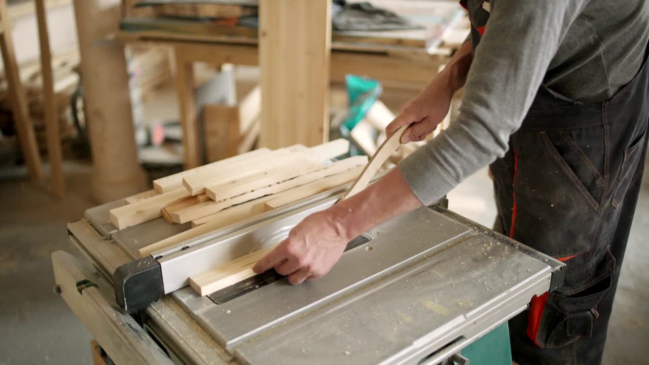 vista de alto ángulo de un hábil fabricante de muebles aserrando tablas de madera con sierra circular en su taller