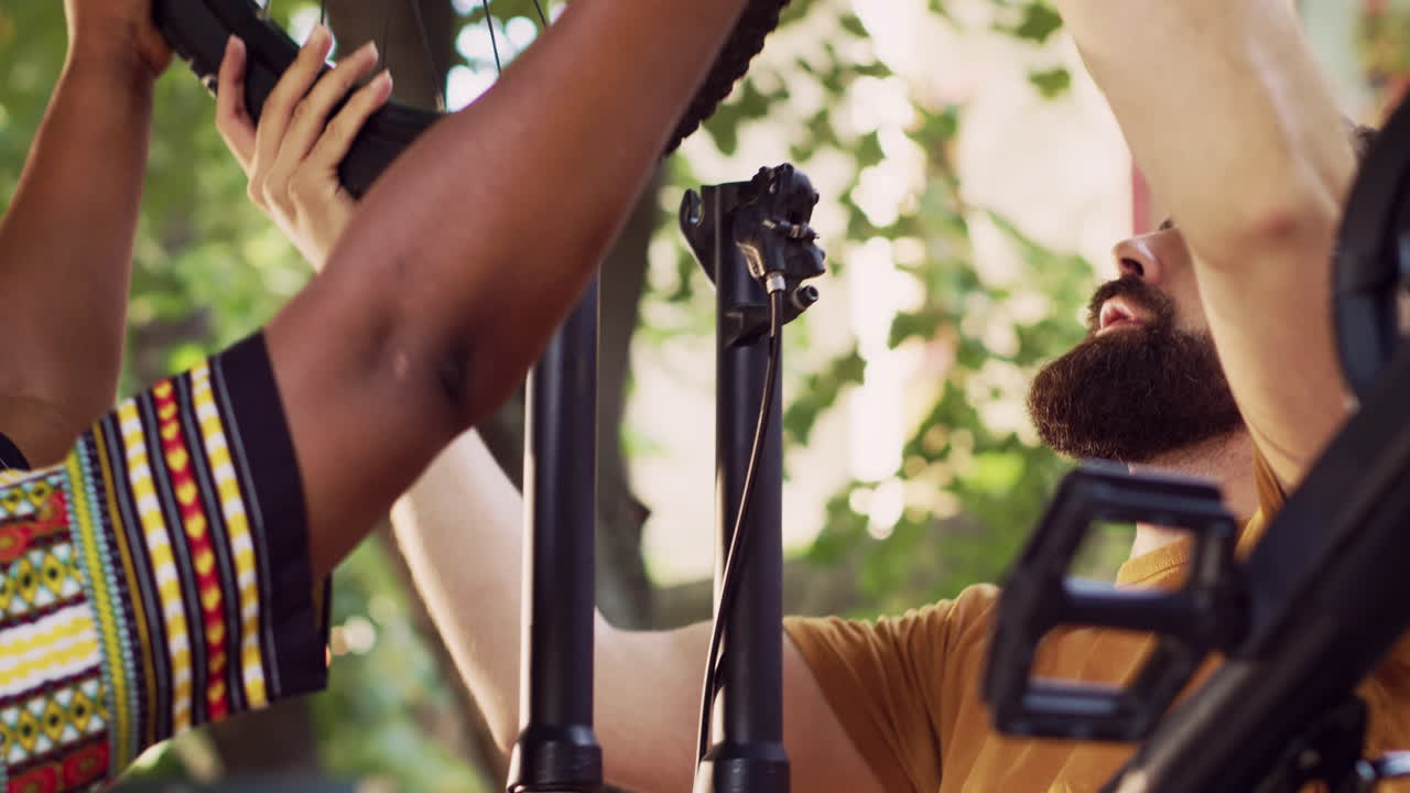 pareja joven colocando la rueda en la bicicleta