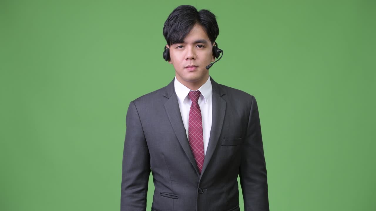 젊은 잘생긴 아시아 사업가 콜 센터 대표로 일하고 있습니다.