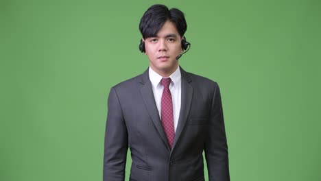 joven y guapo hombre de negocios asiático que trabaja como representante de un centro de llamadas
