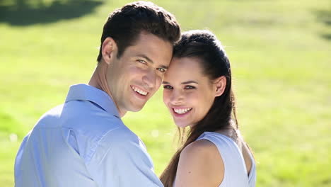 una pareja feliz posando en el parque.
