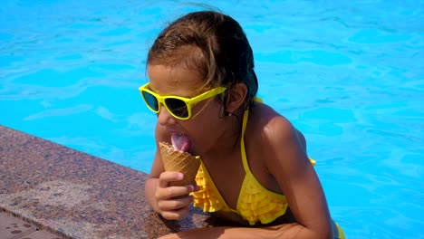 the child eats ice cream near the pool. selective focus. kid.